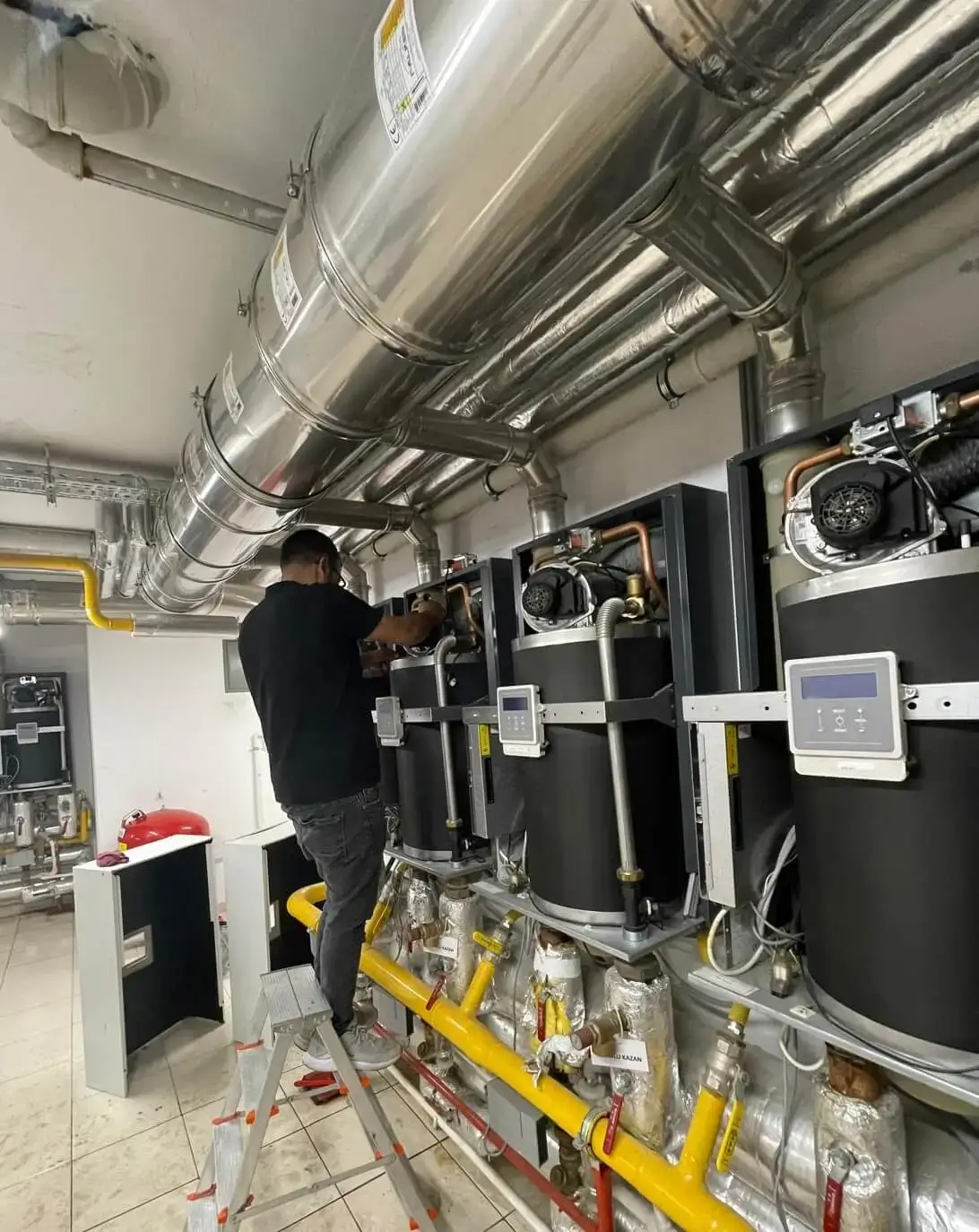Merkezi ısıtma sisteminde teknik kontrol yapan servis personeli