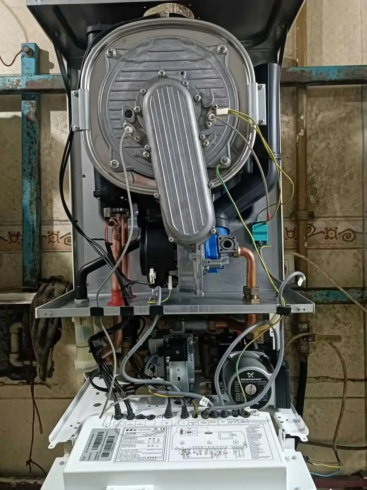Bakım için kapağı açılmış kombinin iç aksamı